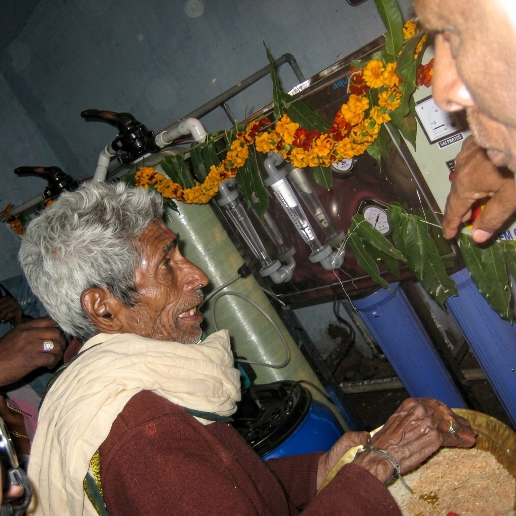 Elder man at the decorated water purification plant inauguration